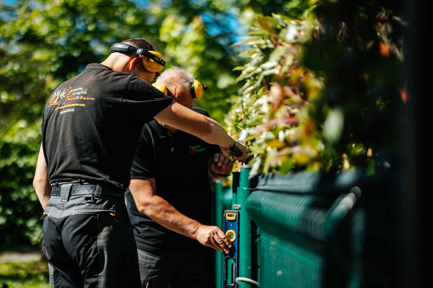 Photo de paysagers entrain de poser une barrière pour un aménagement paysager